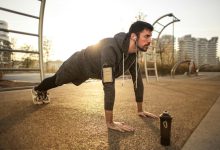 Man in Gray Jacket Doing Push-Ups During Sunrise