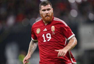 Футболіст у червоній формі збірної Угорщини під номером 19 на полі під час матчу, демонструє активну гру та спортивний дух.